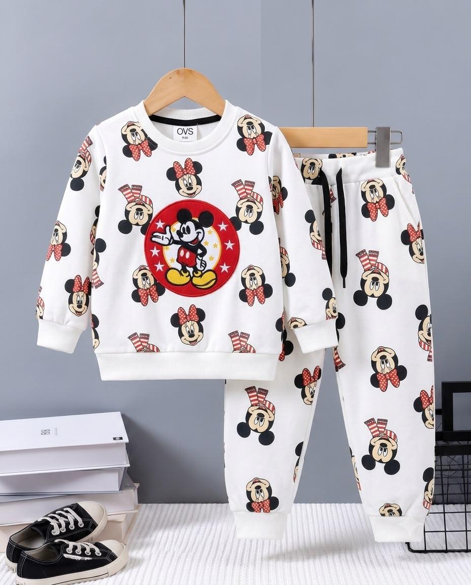 A children's two-piece sweatshirt and pants set featuring an all-over Mickey Mouse print on a white background. The sweatshirt has a large red circular Mickey graphic on the chest, and the pants have matching Mickey prints.
